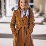 Business woman happy in coat in the street