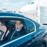 Smiling elegant man making call during transfer from plane