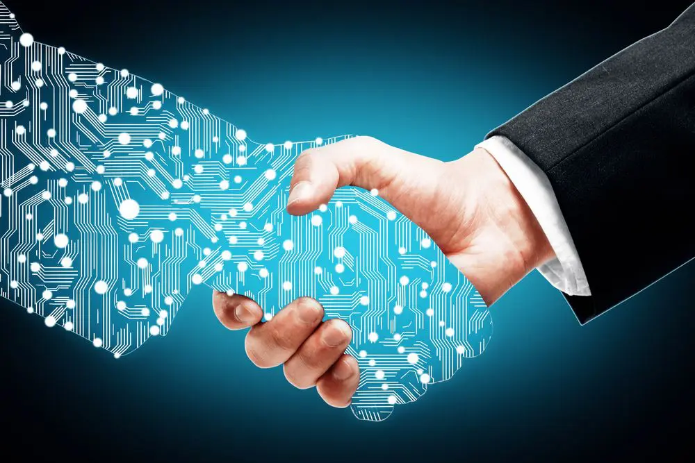 A hand holding a glowing, blue, circuit board-patterned shape that symbolizes digital transformation or technology