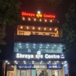 Front view of Shreya Eye Clinic building, brightly lit at night, showcasing the entrance and signage for advanced eye care services.