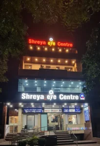 Front view of Shreya Eye Clinic building, brightly lit at night, showcasing the entrance and signage for advanced eye care services.