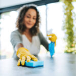 A woman cleans the kitchen counter