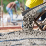 A construction team installing a reinforced concrete garage base in the UK, showcasing the essential groundwork that typically costs between £4,500 and £7,500 for a double garage.