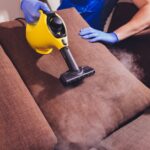 dry-cleaner-s-employee-removing-dirt-from-furniture-flat-closeup_152904-2668