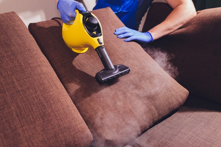 dry-cleaner-s-employee-removing-dirt-from-furniture-flat-closeup_152904-2668