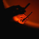 Person using smartphone in the dark with dramatic red lighting