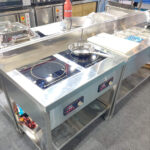 Free standing induction cooking station with dual induction burners in commercial kitchen setup