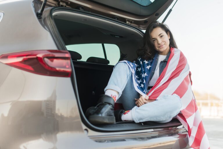 brunette-woman-wearing-big-usa-flag-car-trunk