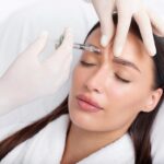 Young,Woman,Recieving,Injection,Of,Anti-aging,Botox,Filler,To,Forehead