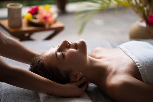 Smiling woman relaxing during her massage treatment at the spa.