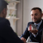 Estate agent shaking hands with his customer after contract signature